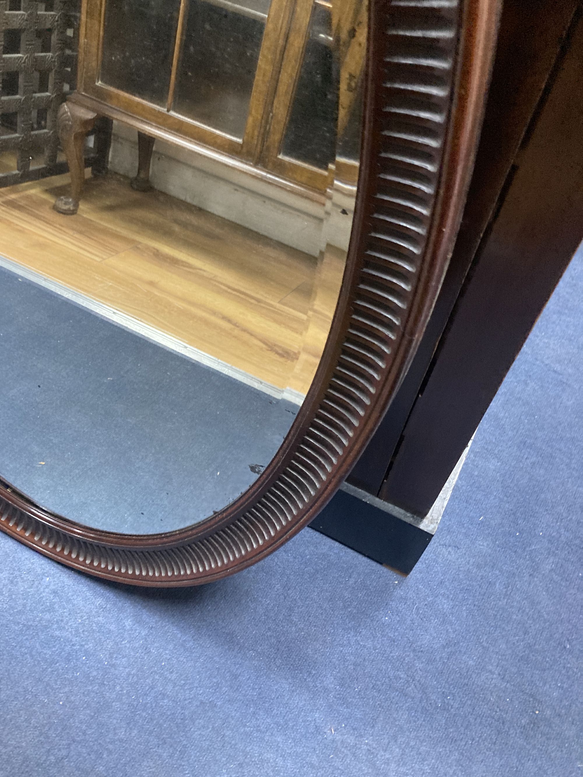 A 1920s oval-framed mahogany wall mirror, width 70cm, height 100cm